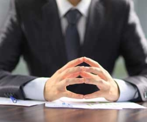 Boss At Desk With Fingers Touching Picture