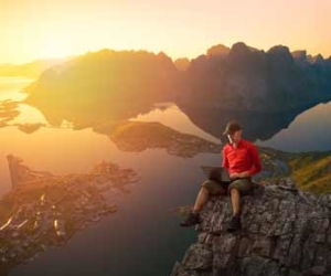 Man Works On Computer While Sitting On Cliff Picture