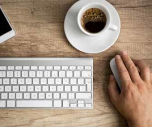 Man Using Computer Mouse While Drinking Coffee