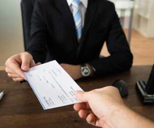 Boss hands check to employee on payday.