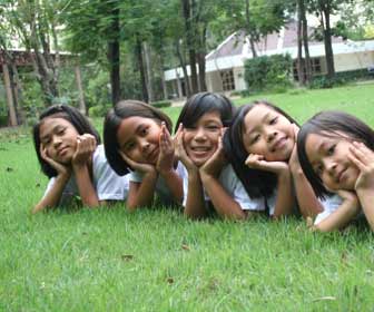 ESL Students Pose for Photo Laying on Grass