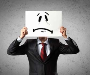 Man in suit holding frowning face sign picture