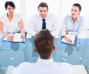 Man at job interview looking at three interviewers