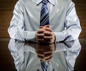 Job candidate sitting at shiny desk during job interview