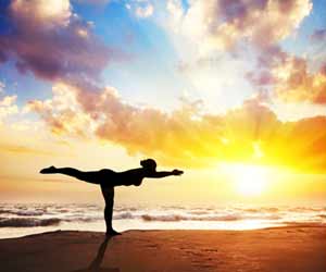 Woman doing Yoga on the Beach