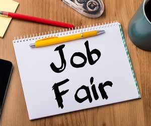 Note on desk with job fair written in black marker