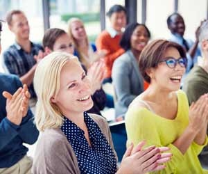 Happy co-workers clapping during employee recognition event