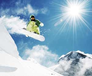 Snowboarder catching air off of natural jump with mountain in background