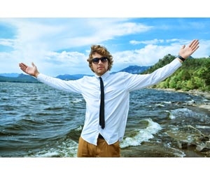 Millennial job seeker with arms raised while standing on beach