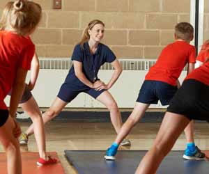 Physical Education Teacher Stretches with Students