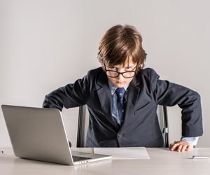 Angry child staring over desk