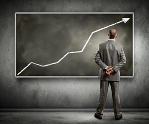 Businessman staring at simple finance chart on wall