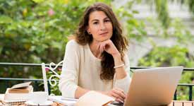 Technical Writer Poses for Photo While Working on Her Laptop