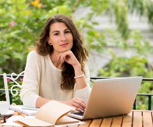 Technical Writer Poses for Photo While Working on Her Laptop