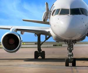 Jet airplane sitting on tarmac while people board