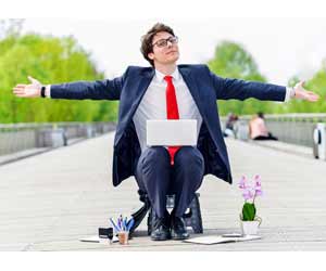 Man in suit working on laptop in an outside "office"