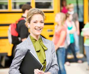 Teacher Greets Students at Bus Stop