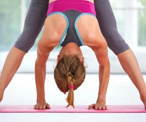 Female yoga instructor with hands between feet