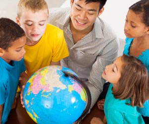 Teacher and students looking at a globe