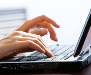 Closeup of hands typing on a laptop