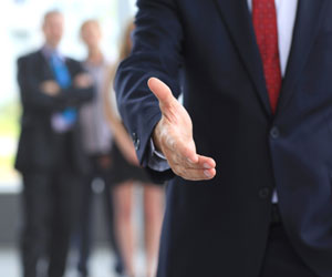 Businessman extends open hand for a handshake