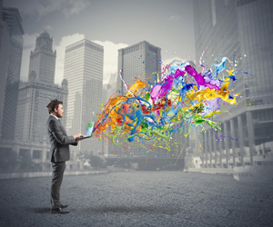 Black and white image of man in city unleashing a vibrant display of colors