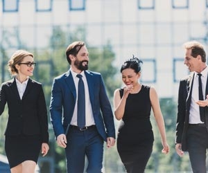 Group of professionals walking outside while making small talk