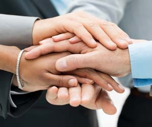 Team of office workers with hands in pile for a cheer