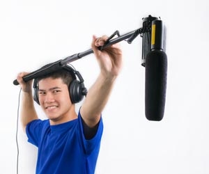 Foley artist holding boom mic while recording sounds