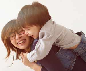 Female Nanny Playing with Child on Her Back Photo